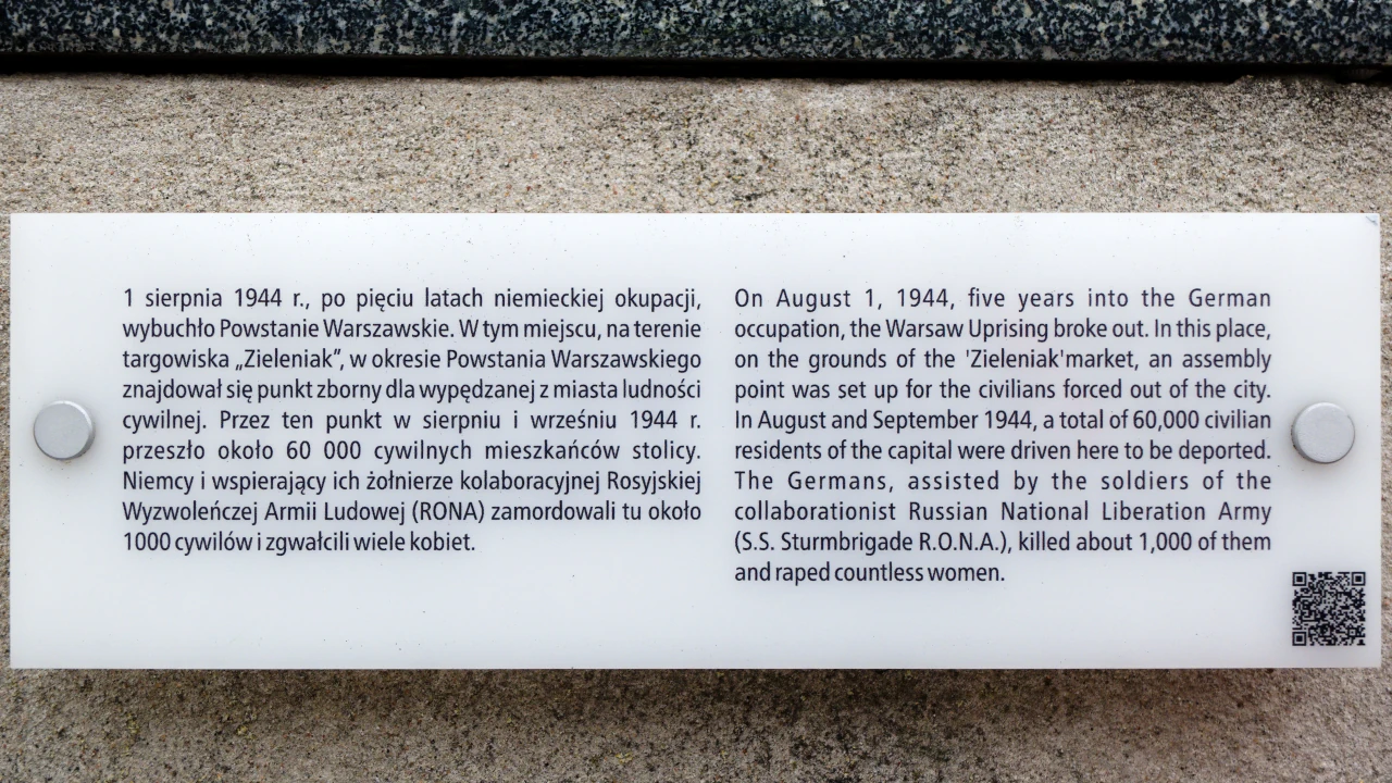 Na ścianie informacja w językach: polskim i angielskim. Informacja o Zieleniaku, który pełnił rolę punktu zbiorczego podczas Powstania Warszawskiego.