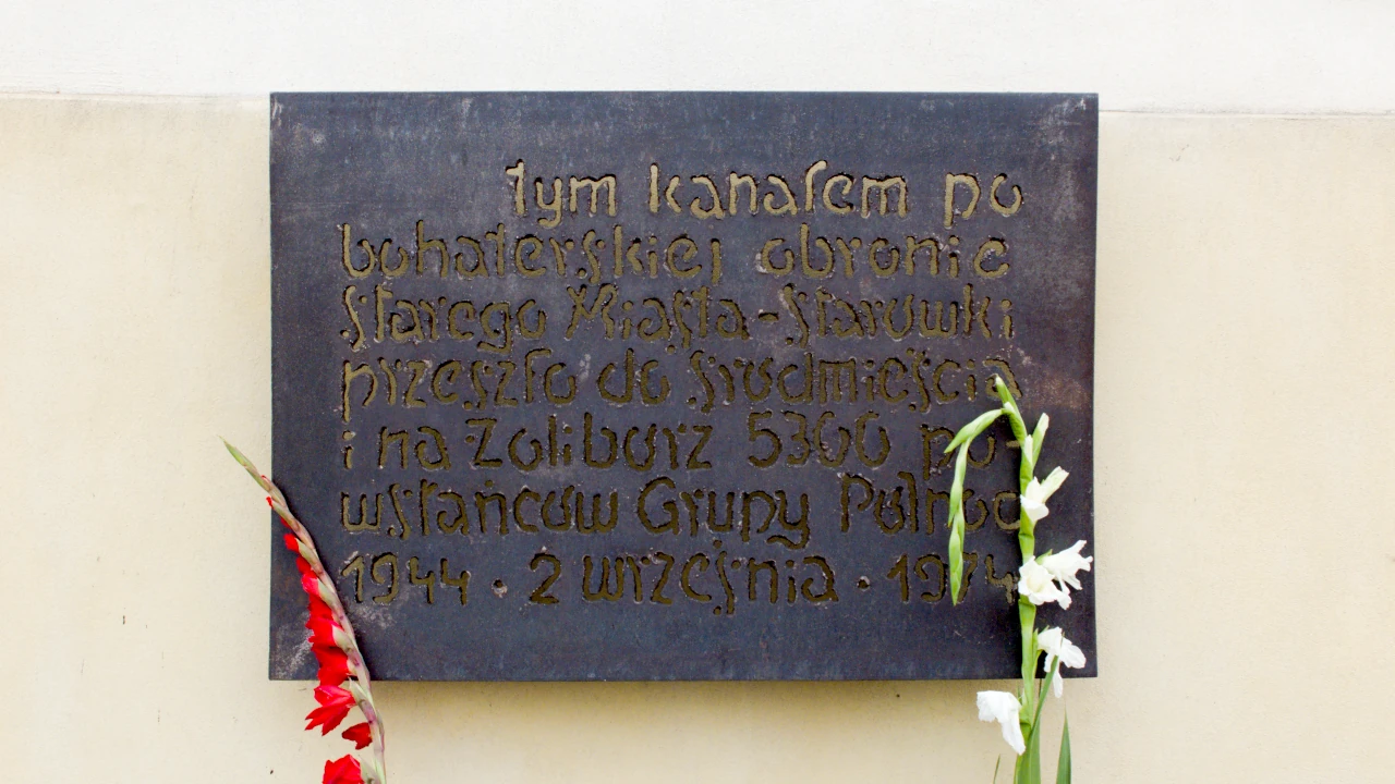 Tablica na budynku informująca o powstańczej ewakuacji kanałami.