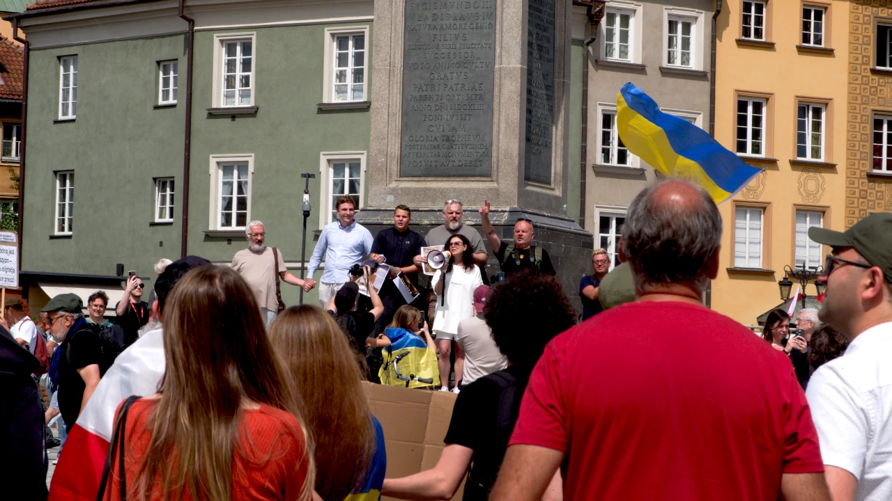 Zbliżenie na osoby stojące pod Kolumną Zygmunta.