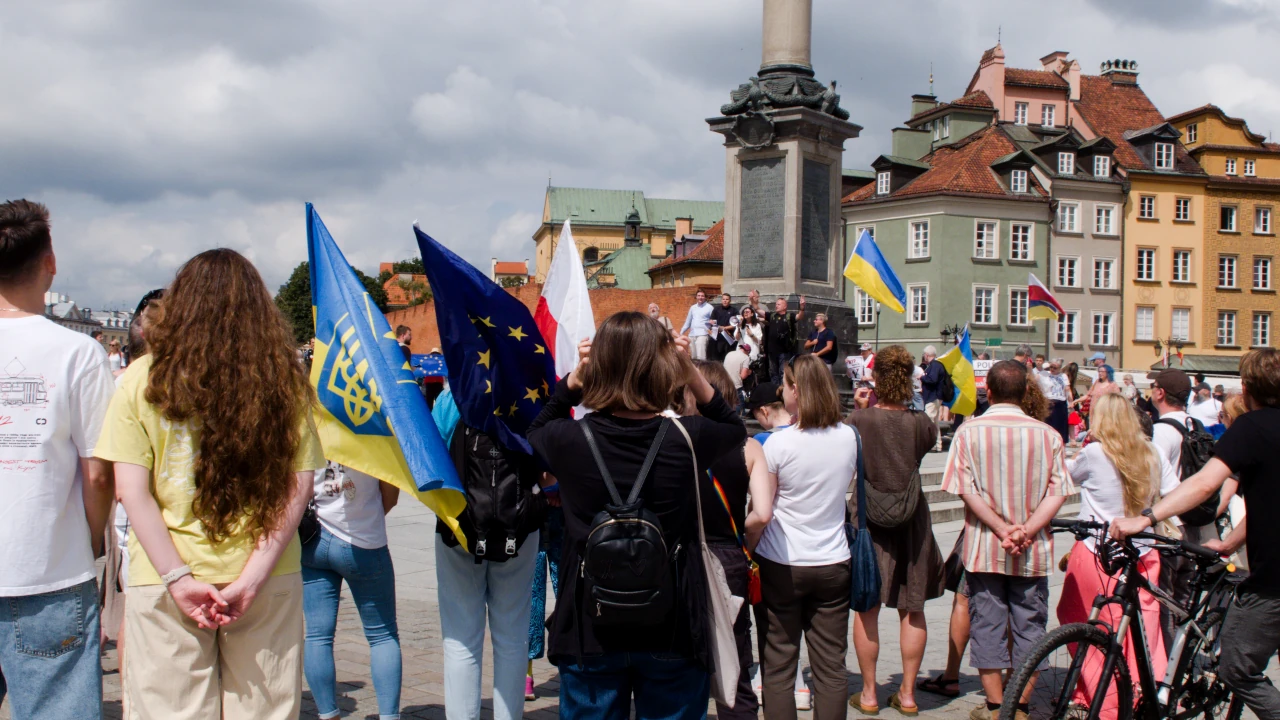 Wiele osób zgromadzonych pod Kolumną Zygmunta. Widać flagi ukraińskie, polskie i Unii Europejskiej.
